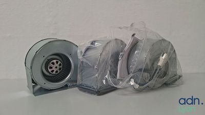 un petit ventilateur posé sur une table, à côté d'un sac en plastique