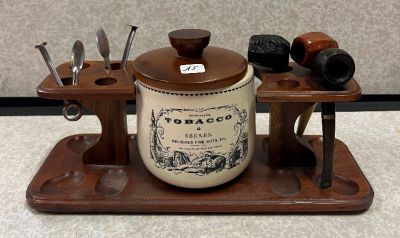 un plateau en bois sur lequel se trouvent un pot de tabac et un porte-pipe