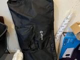 a black bag sitting on the floor next to a pile of boxes