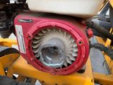 a close up of a red and white engine on a yellow tractor