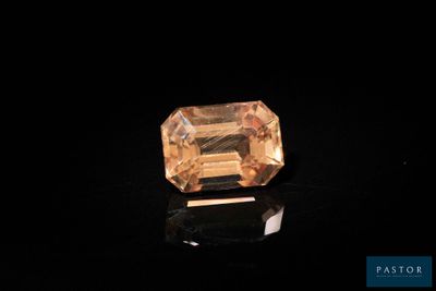 an orange sapphire stone on a black surface