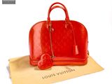 a red louis vuitton bag sitting on a piece of paper