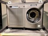 une machine à laver à l'ancienne posée sur un plan de travail