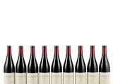 six bottles of red wine lined up in a row