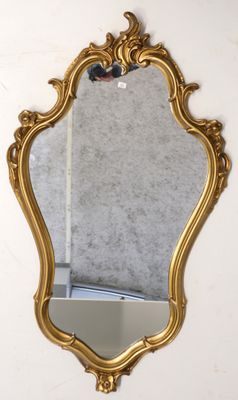 un miroir doré accroché au mur d'une pièce