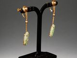 a pair of gold and jade earrings