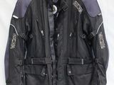 une veste de moto noire et violette suspendue à un cintre sur fond blanc