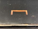 a black box with a brown handle on a table
