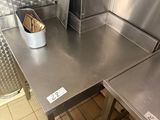 a metal table with a basket on it in a kitchen