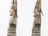 pair of silver colored sculptures of a man and a woman wearing hats
