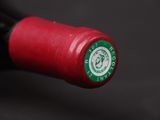 a close up of a red wine bottle with a green label