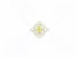 une bague en or blanc sertie d'une pierre jaune entourée de diamants
