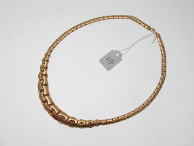 gros plan sur un collier en or portant une étiquette
