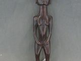 une statue en bois d'un homme avec un chapeau sur la tête