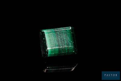 un gros plan d'une émeraude verte sur une surface noire