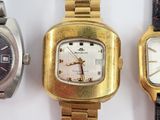 three watches are sitting next to each other on a white surface