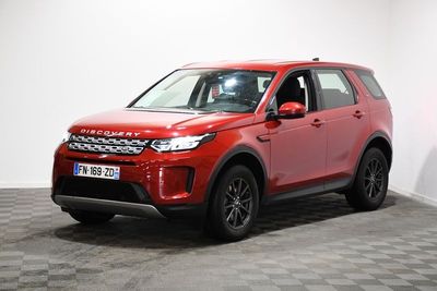 Une Land Rover rouge est garée dans une pièce au sol carrelé en damier.