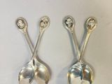 three silver spoons are sitting on top of a white surface