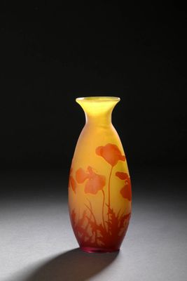 un vase jaune orné de fleurs orange posé sur une table