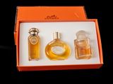 an orange box containing three bottles of perfume and a bottle of cologne