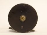 an image of a close up of a fishing reel on a white surface