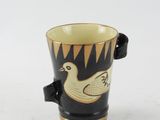 a black and yellow cup with a duck on it