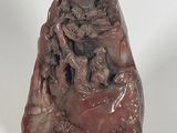 statue of a man sitting on a rock holding a baby