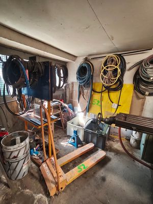 une photo d'un garage avec beaucoup d'outils sur le sol