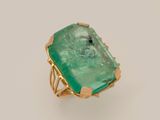 a close up of a ring with a green stone on it