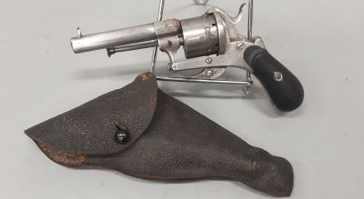 un pistolet et un étui posés sur une table blanche