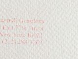 a close up of a piece of white paper with red writing on it