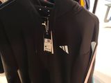 a black shirt hanging on a rack in a store