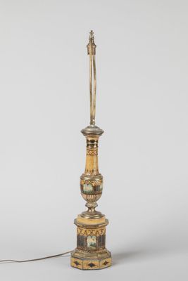 une lampe à l'ancienne avec un pied doré et un pied blanc