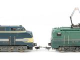 two toy trains sitting side by side on a white surface