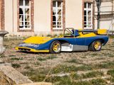 une voiture de course bleue et jaune garée devant un immeuble
