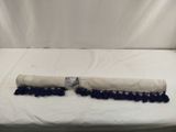 des pompons bleus et blancs sur un lit recouvert d'un drap blanc