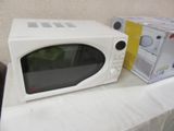 a white microwave sitting on a table next to a box