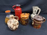 de nombreux vases de styles variés posés sur un fond noir