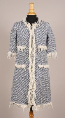 un manteau bleu et blanc à franges sur un mannequin