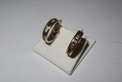 pair of gold tone hoop earrings with black enamel inlays