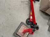 un scooter rouge posé par terre à côté d'une boîte