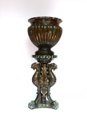a vase that is sitting on a stand on a white surface