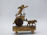 brass figurine of a boy on a cart with a dog