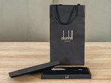 a close up of a black gift bag with a pen in it