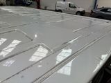 a white car parked in a garage with other cars in the background