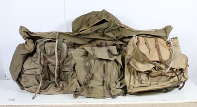 une pile de sacs à dos militaires posée sur une étagère