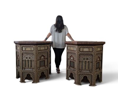 a woman that is standing next to two tables