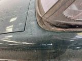 a close up of a car ' s side window with a dog in the passenger seat