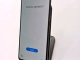 the back of a black phone with a blue button on it
