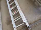 two ladders on the ground next to a window